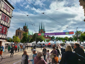 Das Foto zeigt einen Blick auf die Zelte, die auf dem Domplatz aufgebaut sind. Darüber hängt ein Banner mit dem Schriftzug Katholikentag.